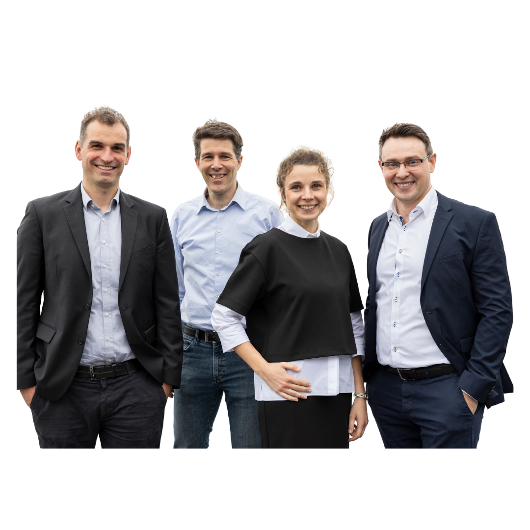 Vier Personen in Businesskleidung vor schwarzem Hintergrund, stehend und in die Kamera blickend.