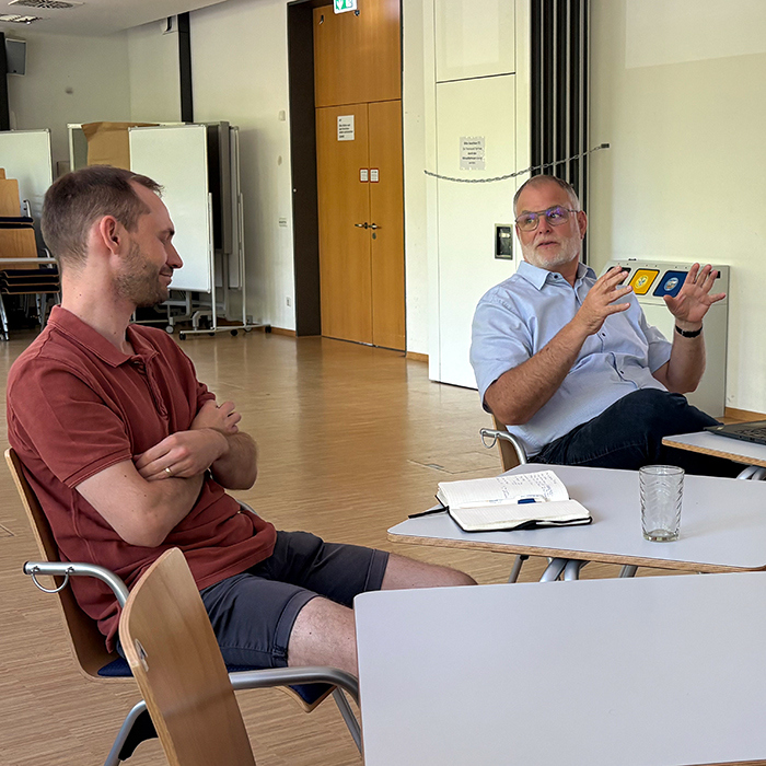 Dr. Ludwig Witter and Dr. Niels Feldmann in a professional setting engaged in a discussion.